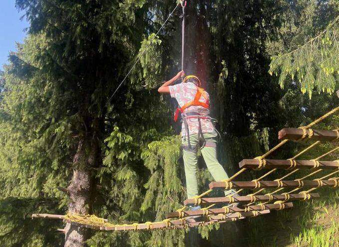 Child crossing a rope bridge in the trees